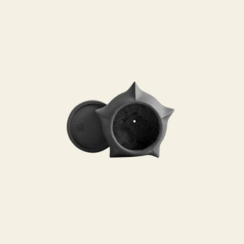 The 101 Copenhagen Arket Plant Pot, Petit by 101 Copenhagen is a matte black, star-shaped sculptural pot with architectural lines and a matching round lid, displayed from above on a plain, light background.