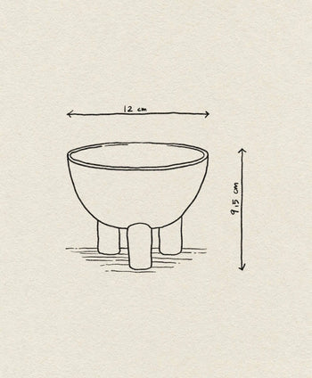 Line drawing of a 101 Copenhagen Duck Bowl, Mini by 101 Copenhagen—a round bowl on three short legs with arrows showing its dimensions: 12 cm wide and 9.5 cm tall, centered on a plain textured background, ideal for modern home decor.