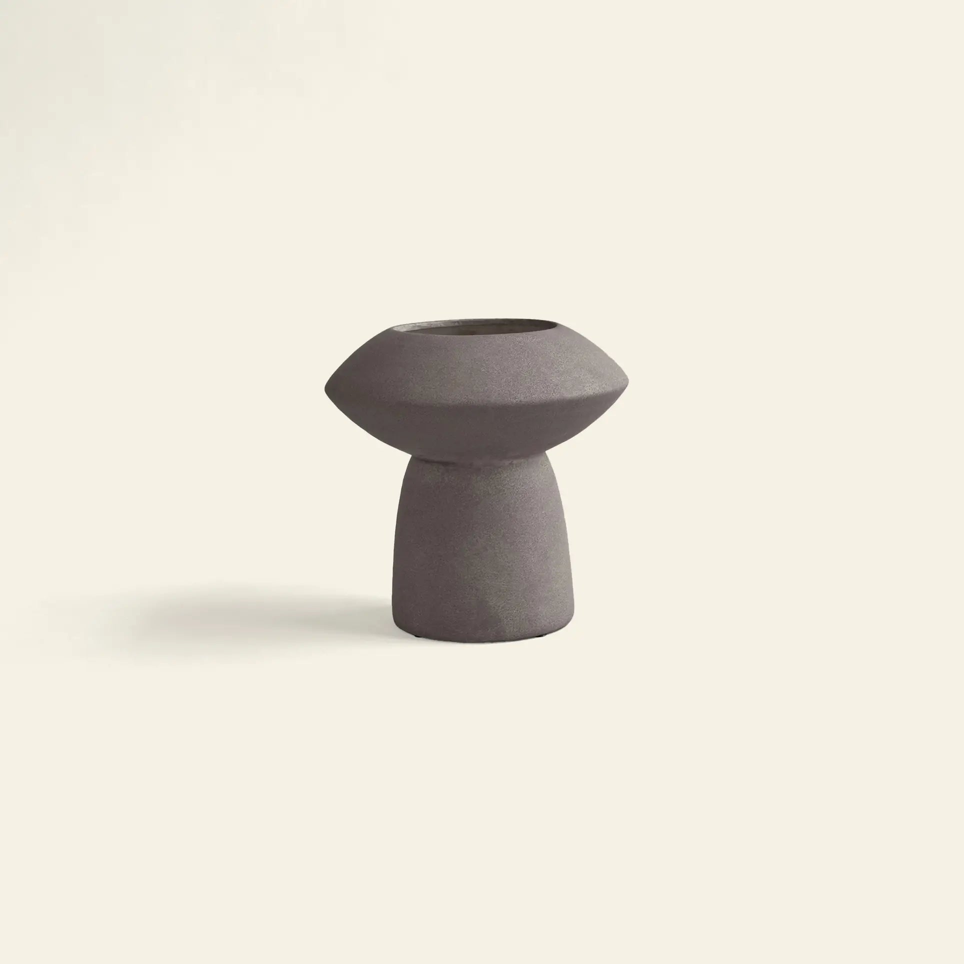 The 101 Copenhagen Sphere Vase Fat by 101 Copenhagen features a minimalist design with a wide, rounded top and narrow base in dark purple ceramic, bringing timeless elegance as a striking centerpiece against light backgrounds.