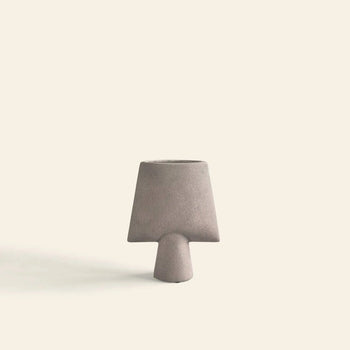 The 101 Copenhagen Sphere Vase Square, Mini features a minimalist matte gray finish with a wide angular top and narrow base—ideal for modern home décor. Brand: 101 Copenhagen. Set against a plain off-white background.