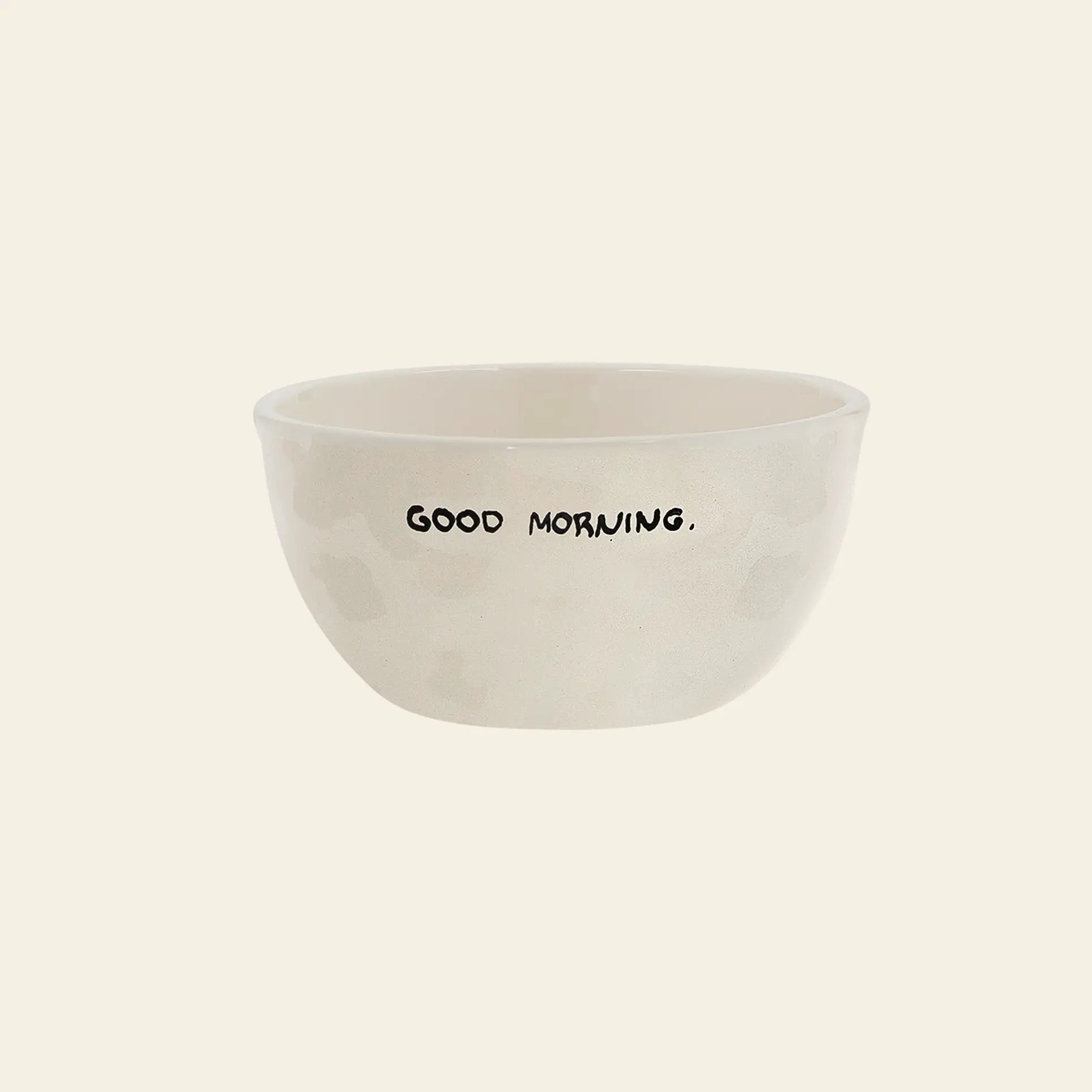 The Anna + Nina Good Morning Bowl by Anna + Nina is a simple off-white ceramic breakfast bowl featuring GOOD MORNING. in bold black uppercase letters on the side, displayed against a plain light background.