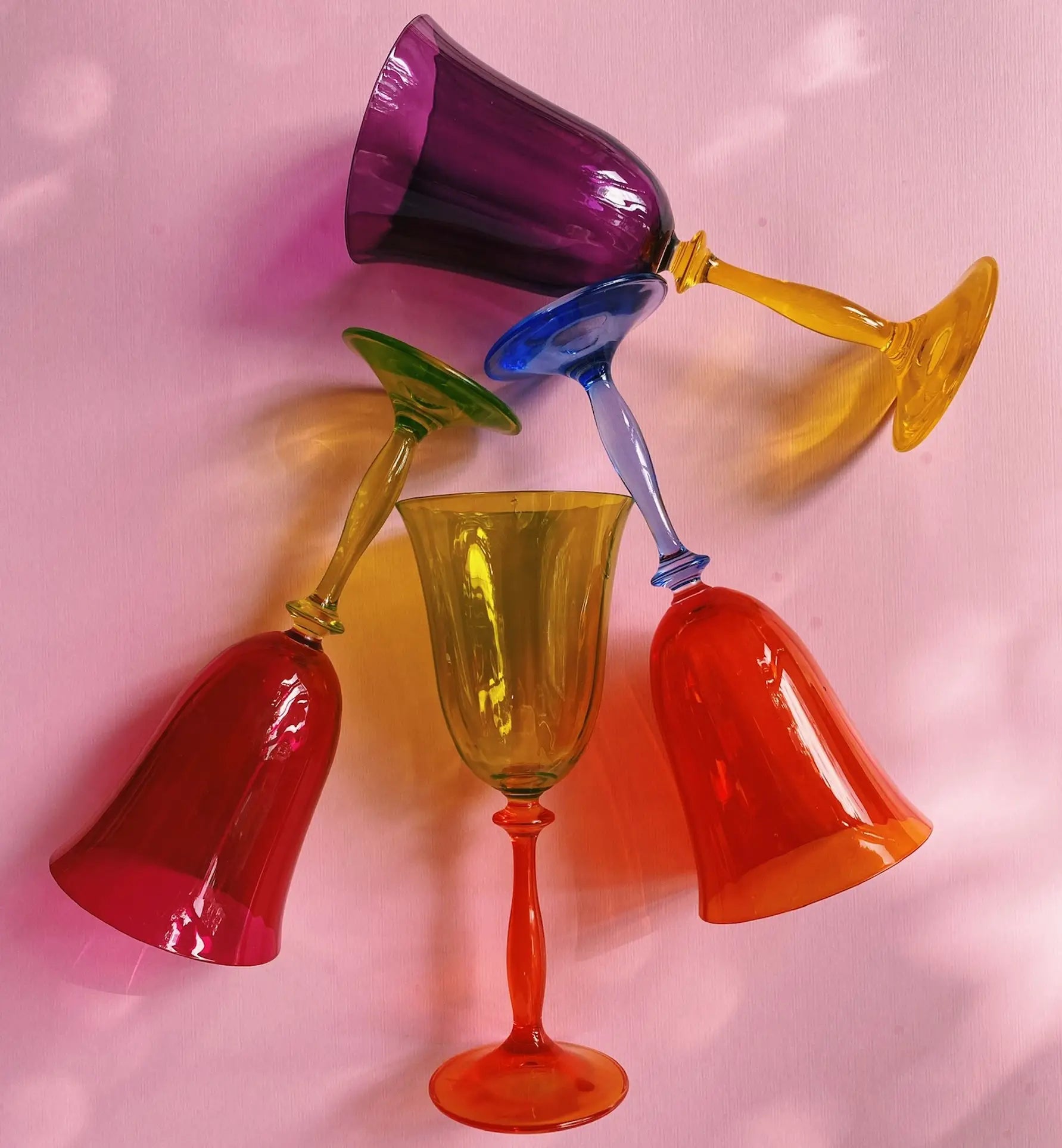 The Anna + Nina Multicoloured Wine Glasses, Set of 4, features vibrant, vintage-inspired goblets in purple, yellow, green, and blue—an artistic and playful gift idea for any home.