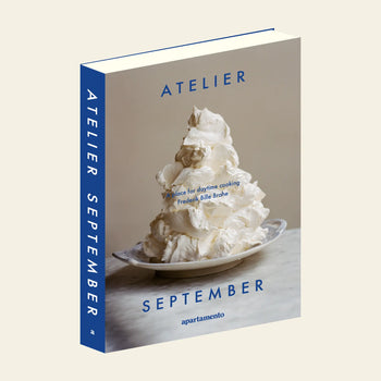 Apartamentos Atelier September: A Place for Daytime Cooking is a cookbook by Frederik Bille Brahe. Its cover features a plate with a swirl of whipped cream or meringue, blue text, and spine on a light beige background.