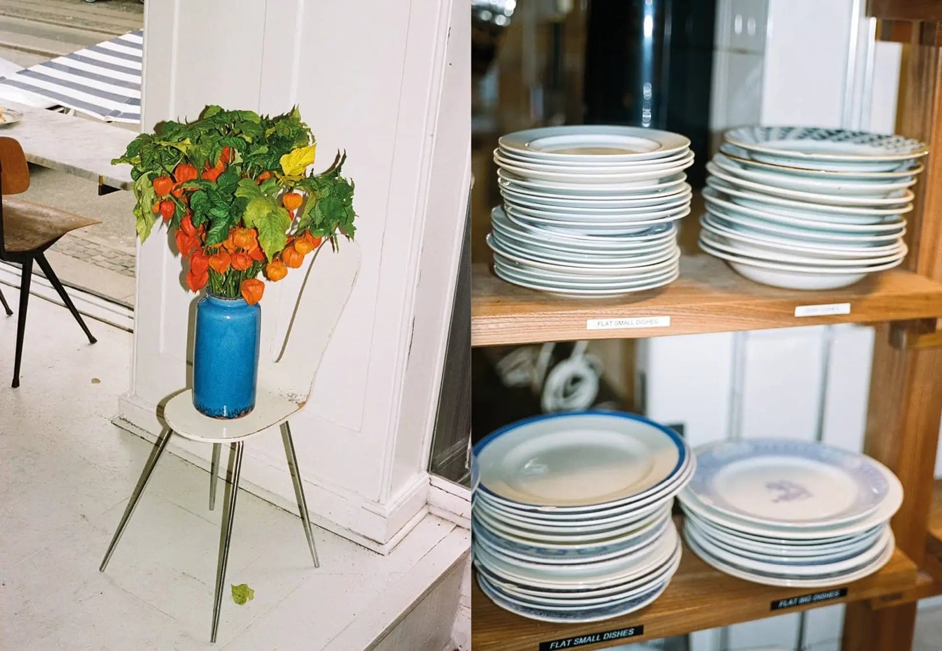 A chair with a blue vase of orange and green flowers sits by a window; nearby, shelves with neatly stacked plates capture the serene ambiance featured in Apartamento’s Atelier September: A Place for Daytime Cooking.