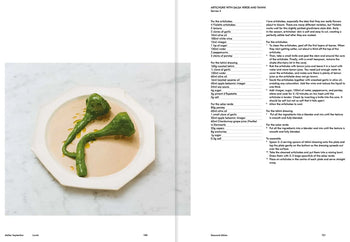 Two green artichoke hearts with salsa verde are plated on a cream dish atop white marble. The right page shows a detailed recipe from Apartamento Atelier September: A Place for Daytime Cooking by Apartamento.