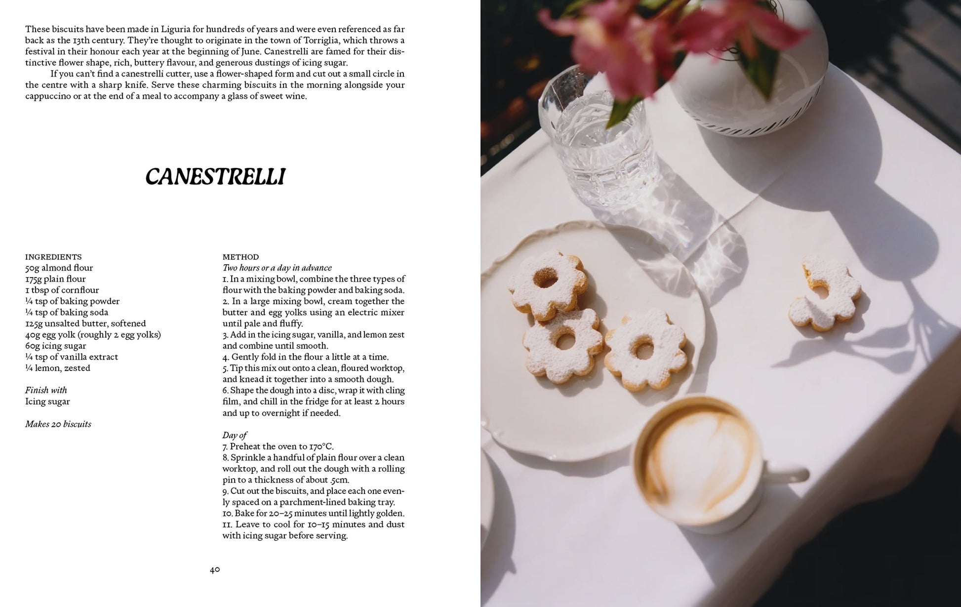 A recipe page from Apartamento LIGURIA: Recipes & Wanderings Along the Italian Riviera by Apartamento is shown alongside a white table with canestrelli biscuits, a cup of coffee, a glass of water, and blurred pink flowers in the foreground.