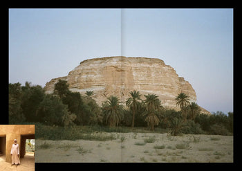 On the cover of Apartamento Magazine Issue #29 by Apartamento, a rocky hill towers over palm trees beneath a clear sky; in the lower left, an inset shows a person in traditional clothing standing in a stone doorway.
