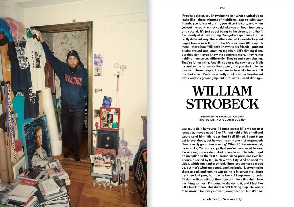 A man stands in a cluttered room, gripping the top of an open wooden door. Books, magazines, and skateboards litter the floor, with walls covered in posters. Featured is an article on William Strobeck in Apartamento Magazine Issue #31 by Apartamento.