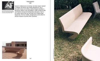 Apartamento Miguel Milá: A Life in Design by Apartamento rests on grass beside plants, its beige, modern concrete form and curved back recalling Milá’s iconic designs. Nearby, benches create an outdoor seating area next to a building.