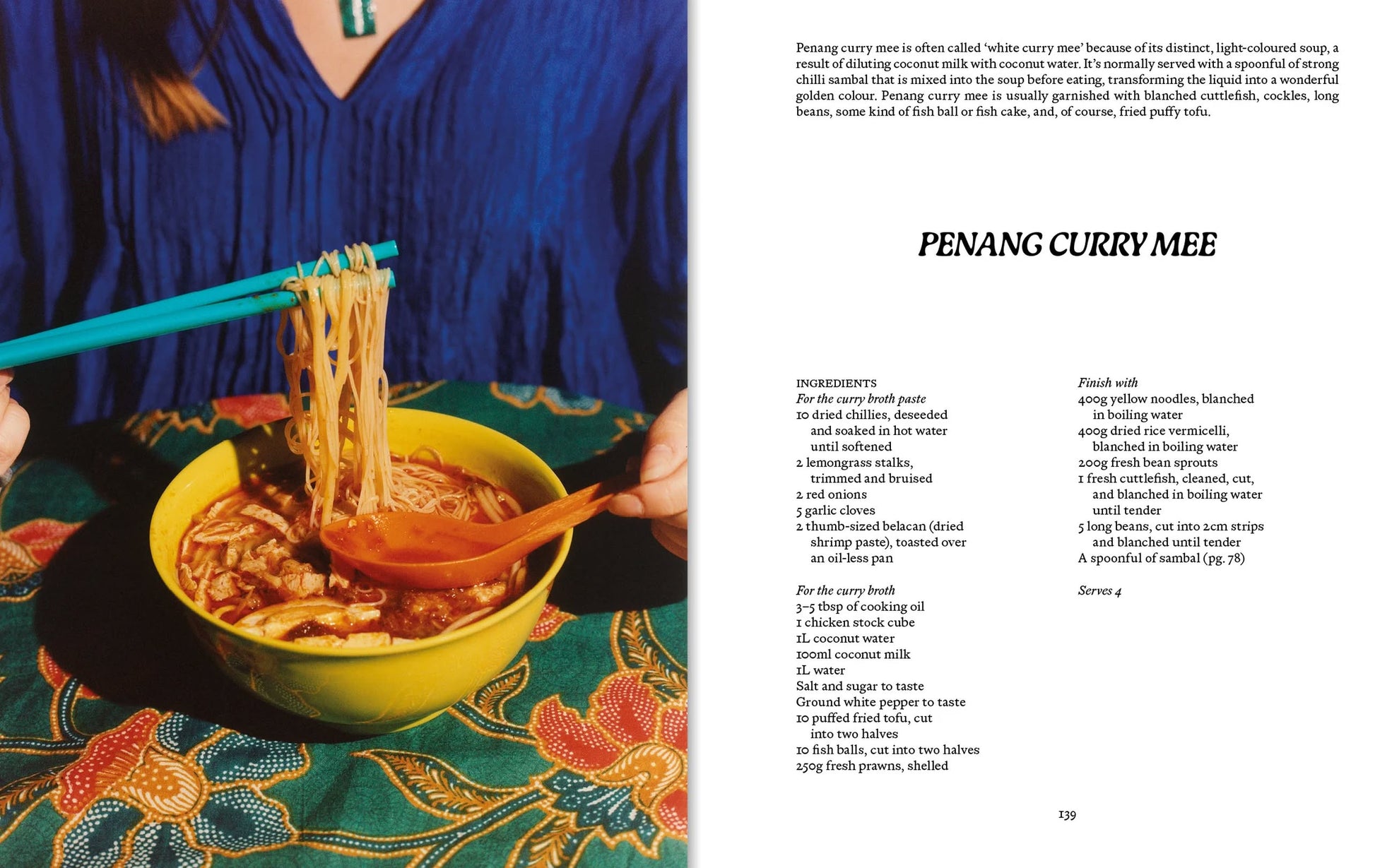 A person lifts noodles with orange chopsticks from a bowl of Penang curry mee, set atop a patterned table, as the recipe appears on the right page of Apartamento PENANG: Recipes & Wanderings Around an Island in Malaysia by Apartamento.
