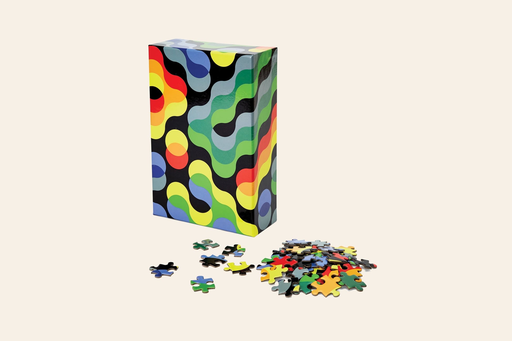 The Areaware Dusen Dusen - Pattern Puzzle, a 500-piece jigsaw with an abstract wavy design, stands upright beside scattered pieces on a plain background—ideal for design enthusiasts.