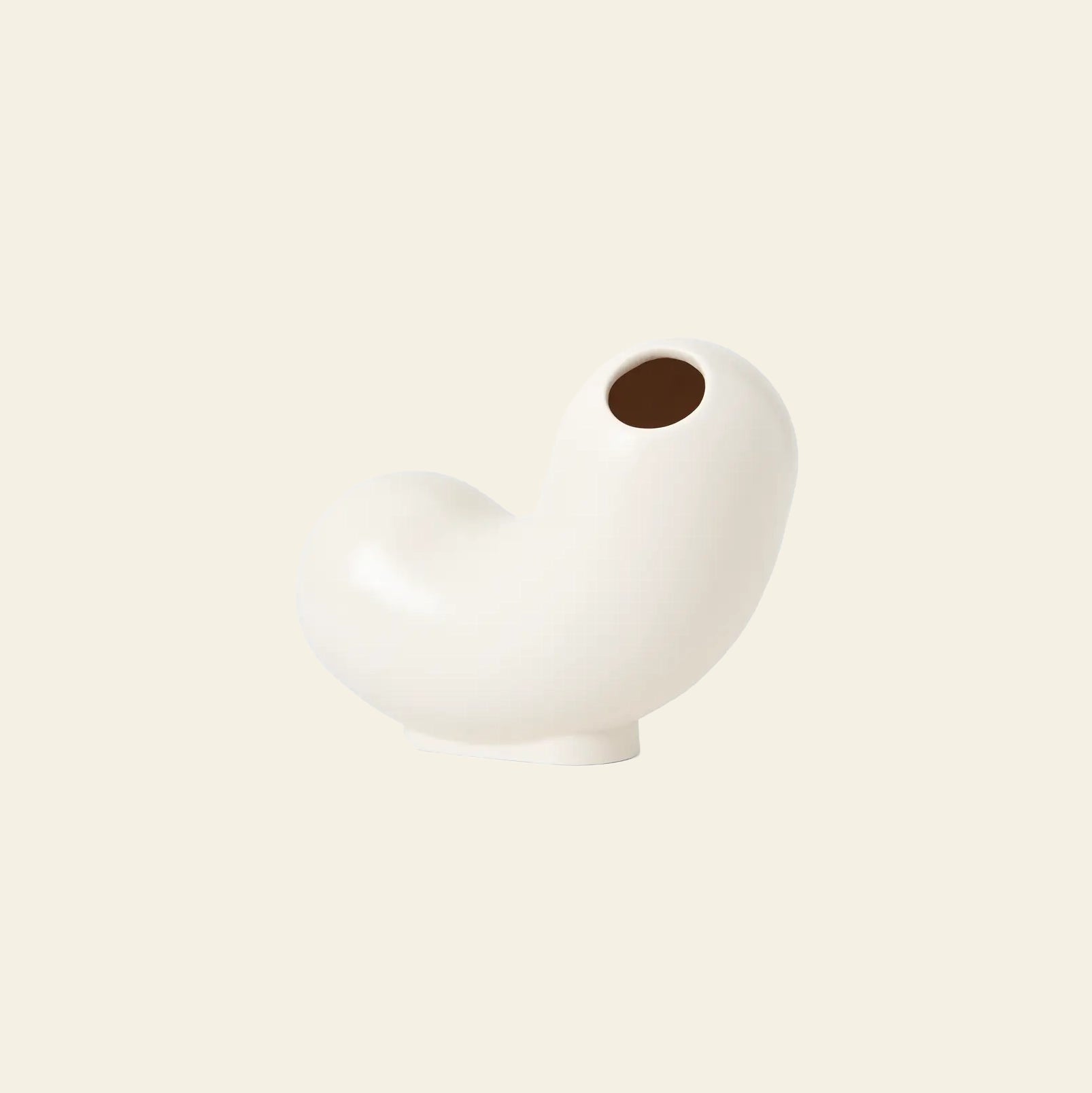 The Areaware Kirby Vase Curly by Areaware features a glossy, off-white ceramic finish and a curvy, bean-like shape with a small round opening—ideal for floral arrangements or adding modern style to your home—displayed on a beige background.