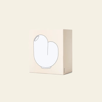 A beige box with a minimalist line drawing of an abstract ceramic vase on the front showcases the Areaware Kirby Vase Jay by Areaware, ideal as a unique bud vase for floral arrangements, all set against a plain light background.
