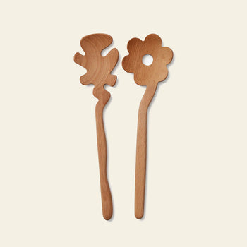Add playful charm to your table with Areaware Serving Friends - Flowers by Areaware: two whimsical wooden salad servers—one a flower with a central hole, the other an abstract blob—set against a light background.