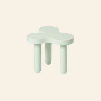 The Areaware Splat Side Table Short by Areaware features a clover-shaped light green seat and three rounded legs, set against an off-white background, evoking a playful and distinctive design.