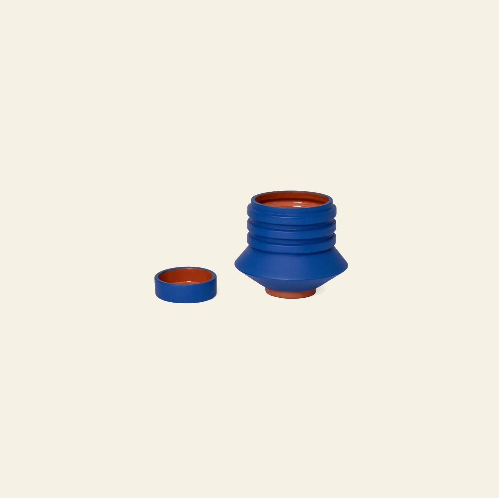 The Areaware Strata Plant Vessel by Areaware, shown open with its lid beside it on a beige background, blends everyday function with sculptural design inspired by Simone Brewster.