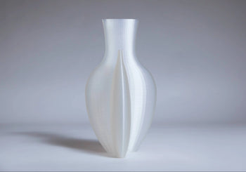 The Argot Studio Double Vessel, by Argot Studio, is a translucent white vase with a smooth 3D-printed surface and symmetrical vertical grooves, elegantly blending modern style with classic design influences.