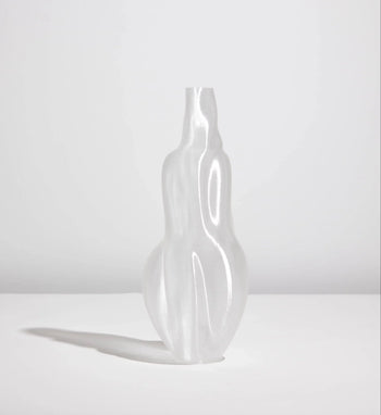 The Argot Studio Éson Vessel, Medium—a translucent, sculptural 3D-printed vase by Argot Studio with smooth, undulating curves—stands on a flat white surface and casts a soft shadow against a light gray background.