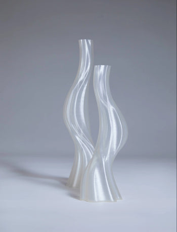 Two tall, translucent Argot Studio Les Hortenses Vases stand side by side against a light gray background, highlighting the contemporary 3D printed design and glossy finish by Argot Studio.