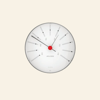 The Arne Jacobsen Bankers Barometer 12cm features a minimalist round design with a white face, black markings, red center, and three black hands to display atmospheric pressure in a clean, numbered layout with rectangular indicators.