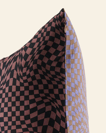 Close-up of the BAGGU Throw Pillow Case by BAGGU, featuring a trippy checker design—wavy black and brown checks on one side, black and lavender checks on the other—perfect for adding flair to your living space.