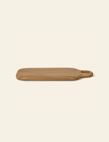 The Bloomingville Abbas Cutting Board by Bloomingville is a rectangular mahogany board with rounded edges and an oval handle, ideal for meal preparation, shown on a plain light background.