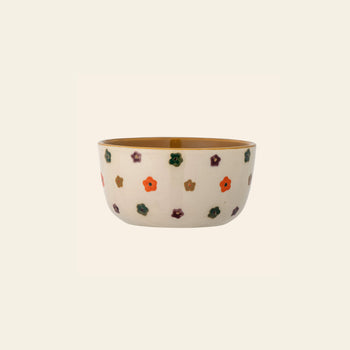 The Bloomingville Addy Bowl is a ceramic children’s bowl with a tan interior, white exterior, and hand-painted orange, purple, green, and brown floral design by Bloomingville, shown centered on a plain light background.