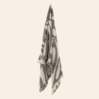 The Bloomingville Alk Throw by Bloomingville features a minimalist woven pattern in green and beige, crafted from recycled cotton with fringed edges, displayed against a plain, light background.