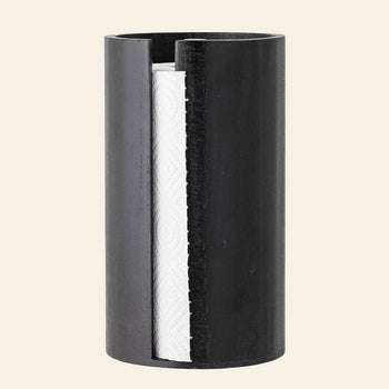The Bloomingville Celian Kitchen Paper Stand, in a sleek black cylindrical design with an open side, elegantly displays a white paper towel roll—bringing Scandinavian style to your kitchen.