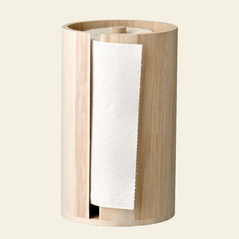 The Bloomingville Celian Kitchen Paper Stand is a cylindrical, smooth, light wood paper towel holder with a vertical slot revealing the roll inside.