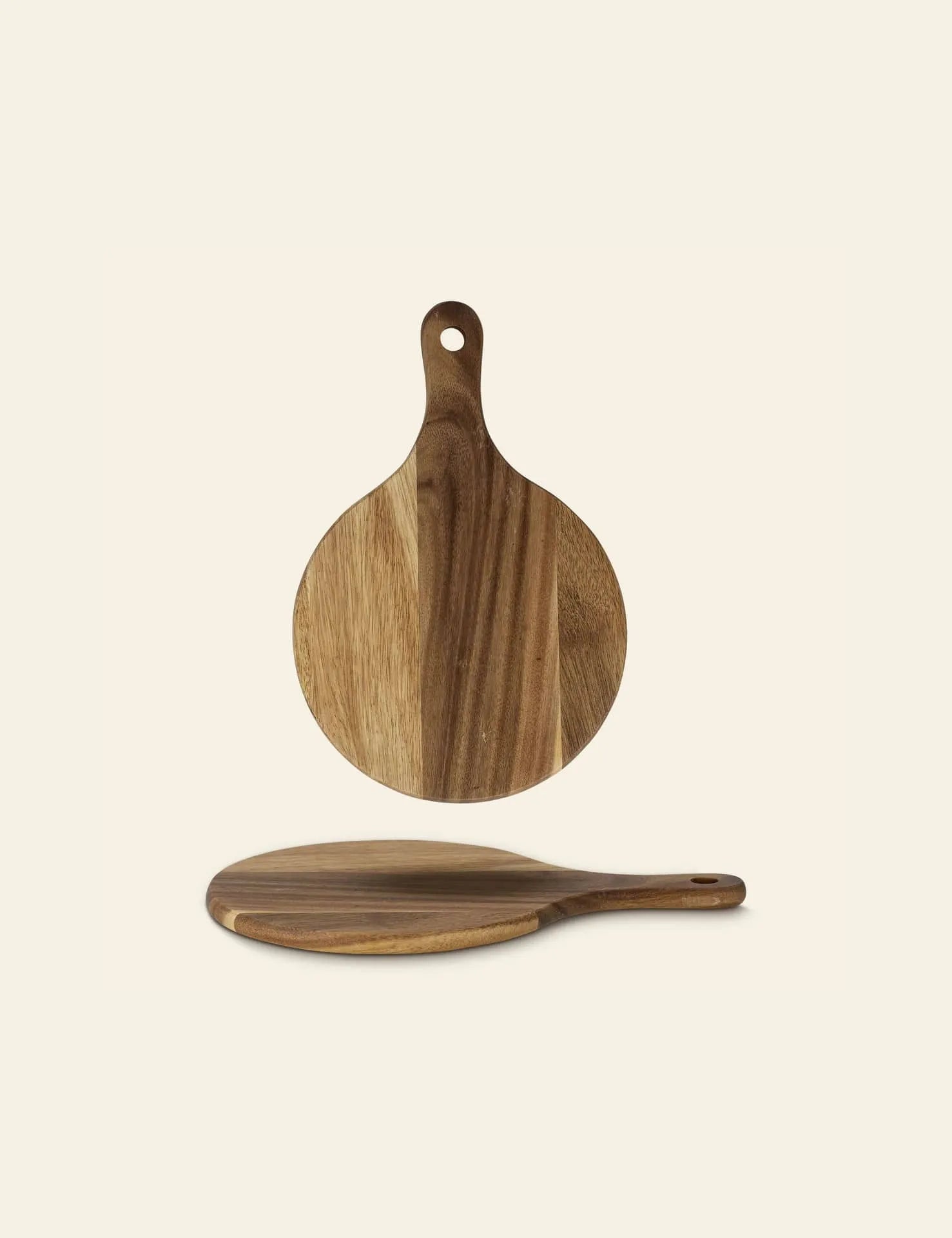 The Bloomingville Dana Cutting Board by Bloomingville features a round beech wood design with a handle and hanging hole, showcased from top and side views to highlight its natural wood grain—an ideal addition to any kitchen.