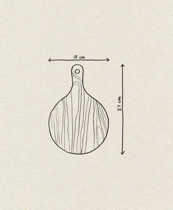 Line drawing of the Bloomingville Dana Cutting Board by Bloomingville, featuring round beech wood with a handle. Measures 18 cm wide by 27 cm long overall. Visible wood grain and a hole in the handle enhance its charm.
