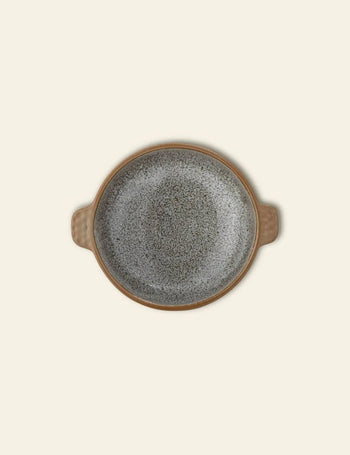 The Bloomingville Hariet Bowl by Bloomingville is a round, speckled gray stoneware bowl with two small opposite handles, shown from above on a plain light beige background.