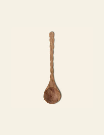 The Bloomingville Ivy Spoon by Bloomingville features a carved, textured wooden handle and rounded bowl, crafted from natural wood and shown on a plain, light background.