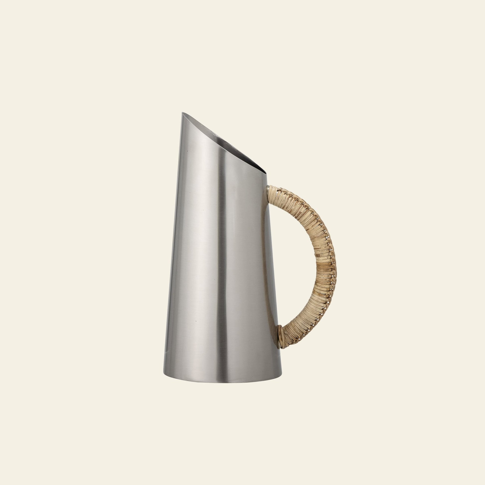 The Bloomingville Juanita Jug by Bloomingville features a contemporary stainless steel design with a narrow spout and rattan-wrapped handle, shown against a plain light background.