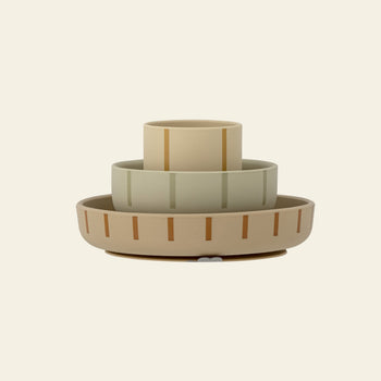 The Bloomingville Levi Tableware Set by Bloomingville features three stackable silicone bowls or cups in beige, sage green, and tan with vertical stripes—perfect for everyday use or as a thoughtful gift for young children.