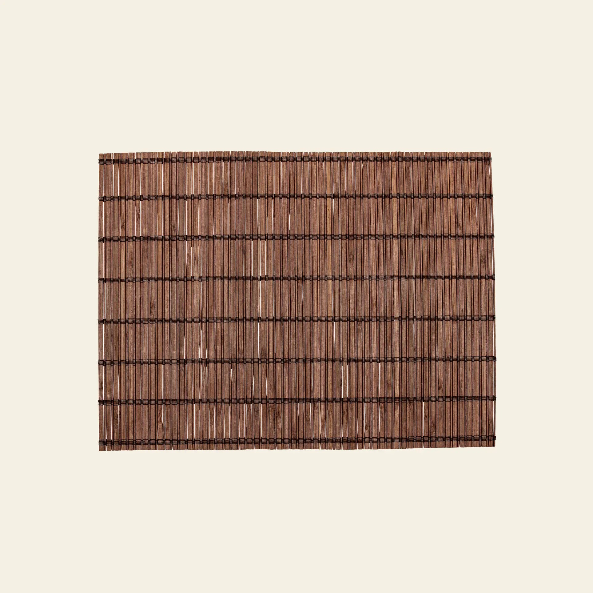 The Bloomingville Maggi Placemat - Brown by Bloomingville features a rectangular bamboo design with dark horizontal and vertical threads, elegantly displayed on a light beige background—perfect for stylish table decor.