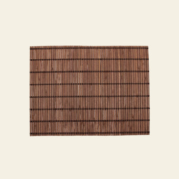 The Bloomingville Maggi Placemat - Brown by Bloomingville features a rectangular bamboo design with dark horizontal and vertical threads, elegantly displayed on a light beige background—perfect for stylish table decor.