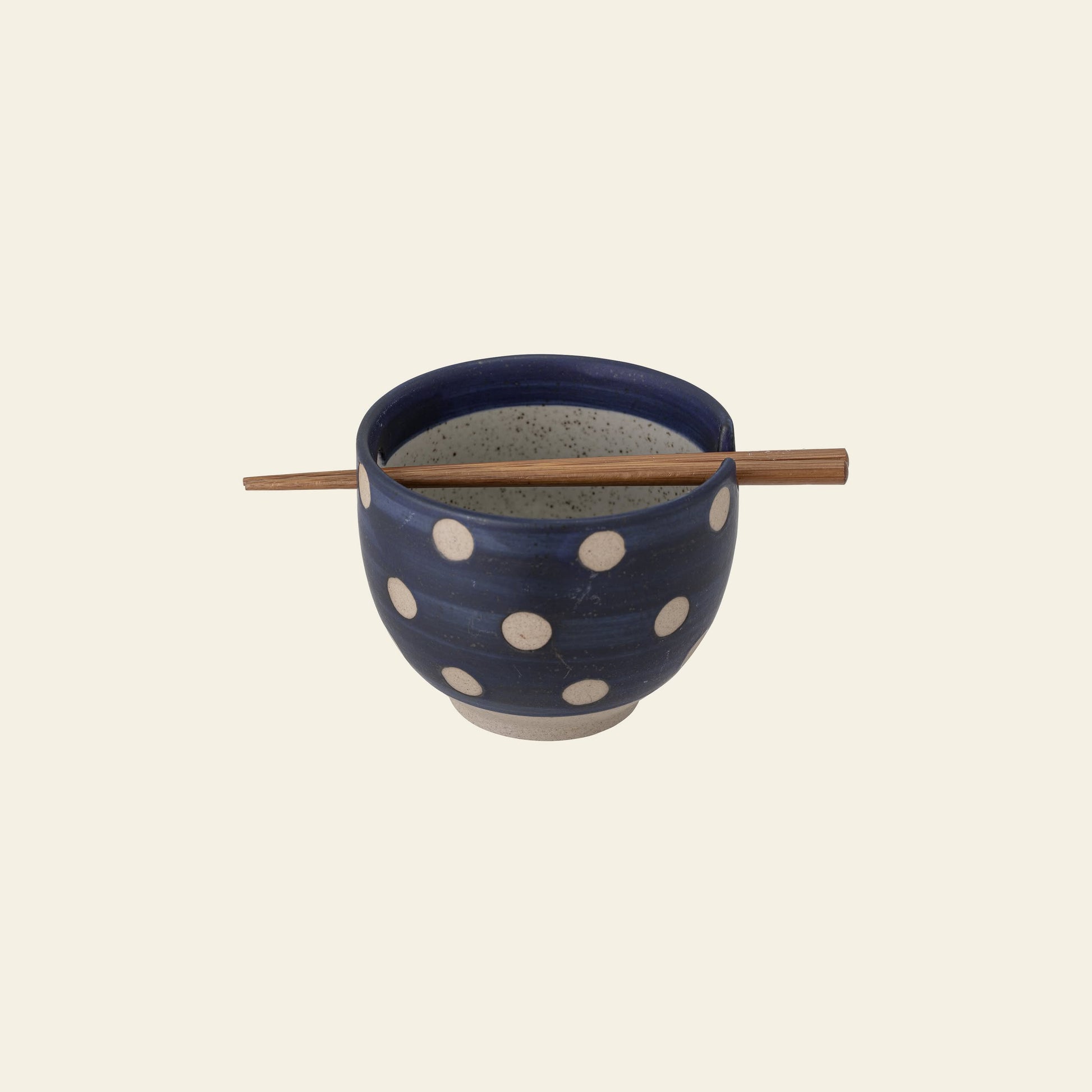 The Bloomingville Masami Bowl w/Chopsticks features blue stoneware with white polka dots and wooden chopsticks resting across the top, making it a charming kitchenware addition from Bloomingville.
