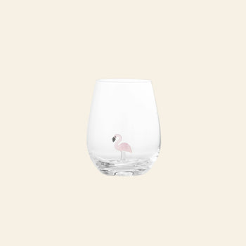 The Bloomingville Misa Drinking Glass by Bloomingville is a clear, handcrafted glass featuring a small pink flamingo illustration, displayed on a plain, light beige background.