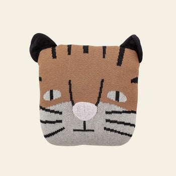 The Bloomingville Muzamel Cushion is a square, knitted soft toy cushion by Bloomingville, featuring a tiger face with black embroidered stripes, pointed ears, a pink nose, and whiskers—a delightful decorative accent for any room.