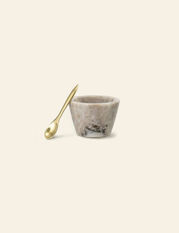 The Bloomingville Rosamynthe Salt Jar w/Spoon sits on a light background, its marbled texture and shiny gold spoon making it perfect for serving spices or as a stylish accent from Bloomingville.