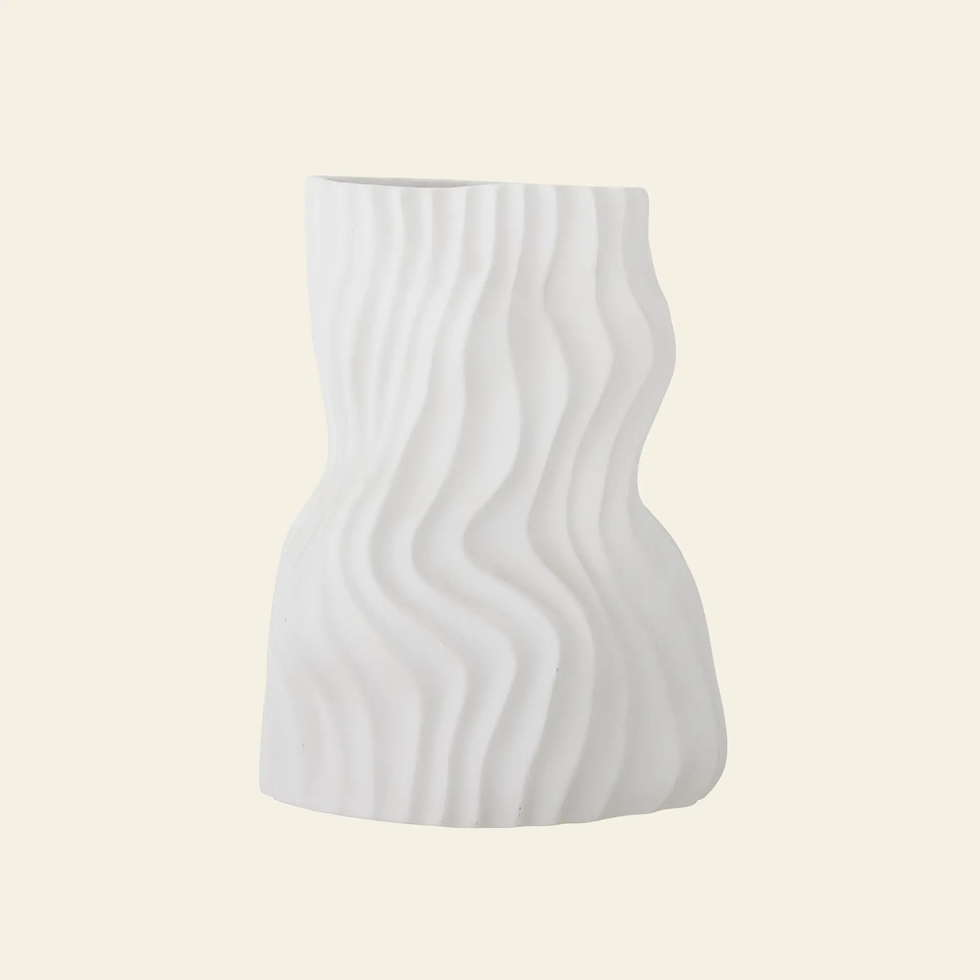 The Bloomingville Sahal Vase by Bloomingville features a white ceramic finish with an irregular, ocean wave texture and a curved shape, set against a light beige background—an eye-catching decorative piece.