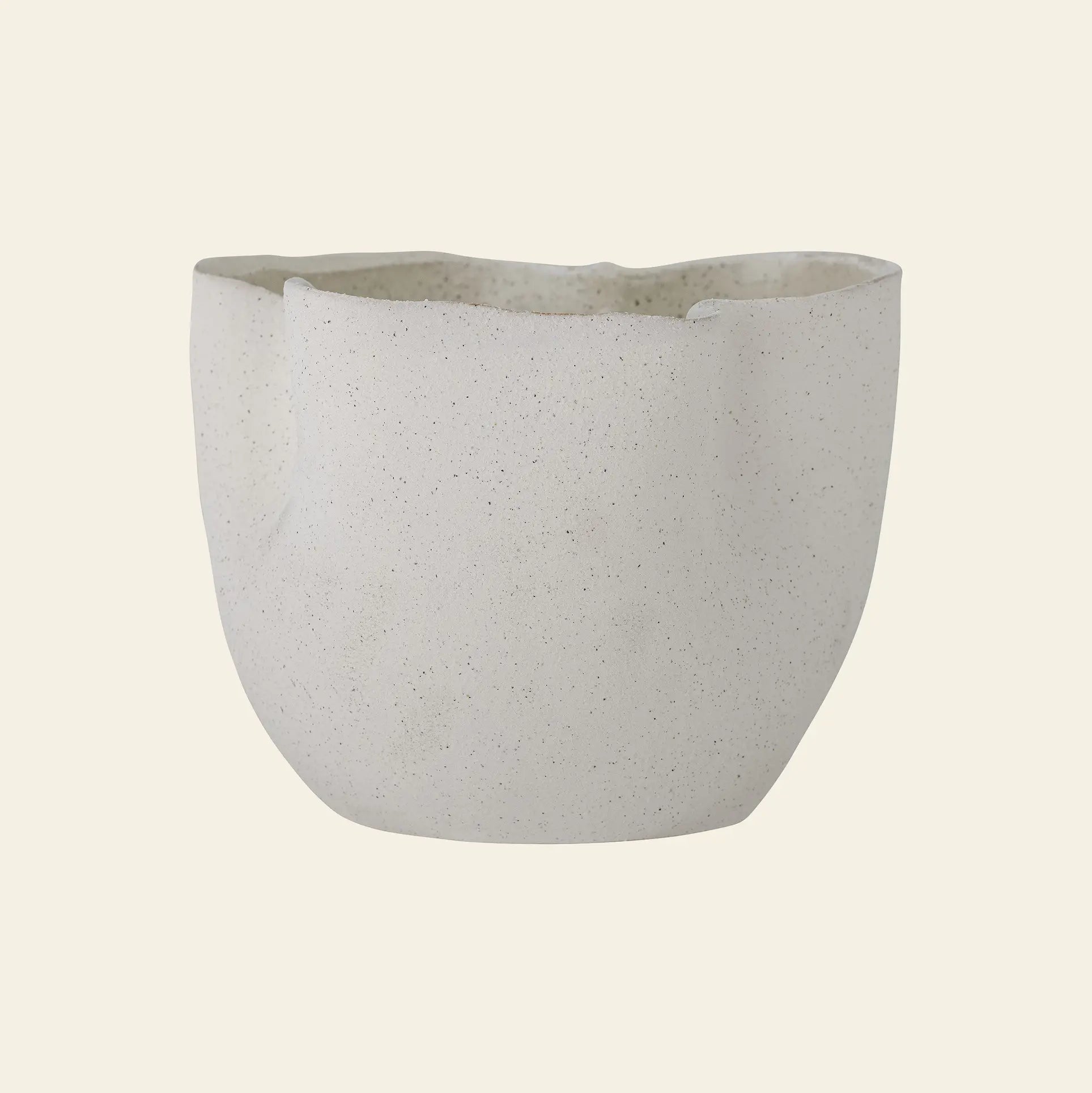 The Bloomingville Sanam Flowerpot by Bloomingville is a contemporary white, speckled stoneware flowerpot with an uneven, organic rim and a matte finish, set against a plain beige background.