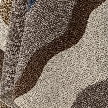 A close-up of the Bloomingville Stephania Throw by Bloomingville, showcasing its recycled cotton texture and woven wavy stripes in brown, beige, gray, and blue for a layered look.