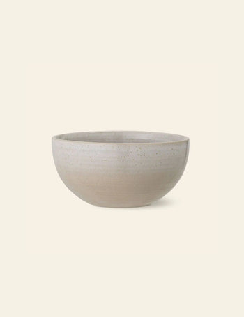 The Bloomingville Taupe Bowl by Bloomingville is a simple, round, durable natural stoneware bowl in light beige with a smooth matte finish and subtle speckled texture, shown against an off-white background.