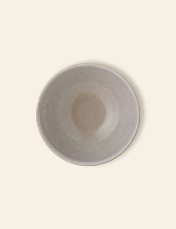 The Bloomingville Taupe Bowl by Bloomingville is a round, shallow natural stoneware bowl with a durable, smooth, speckled light beige glaze, shown from above on a pale background.