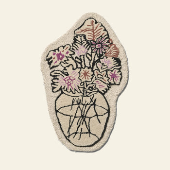The Bongusta Autumn Flowers Rug by Bongusta is handcrafted from 100% wool, featuring an irregular shape and a black line vase with abstract pink and purple flowers on a cream background.