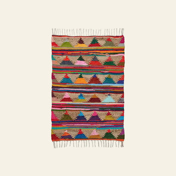 The Bongusta Pyramid Chindi Rug (60x90) features red, green, blue, yellow, pink, and brown geometric patterns in cotton with rows of triangles, horizontal stripes, and fringed edges on both ends.