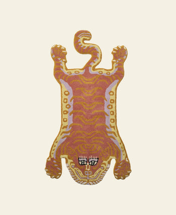 The Bongusta Tigress Rug, Small features a stylized tiger motif with orange, yellow, and pink patterns, bold black and white eyes, and a detailed face from Bongusta, set on a plain cream background.